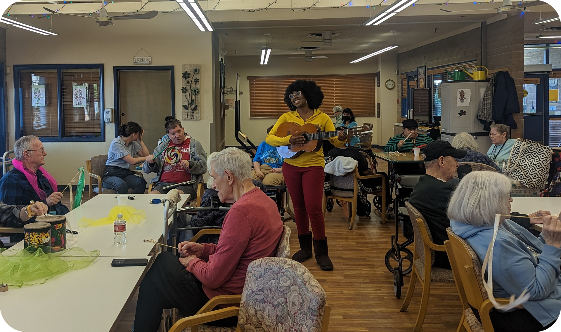 A senior center with a licensed music therapist playing the ukulele at center