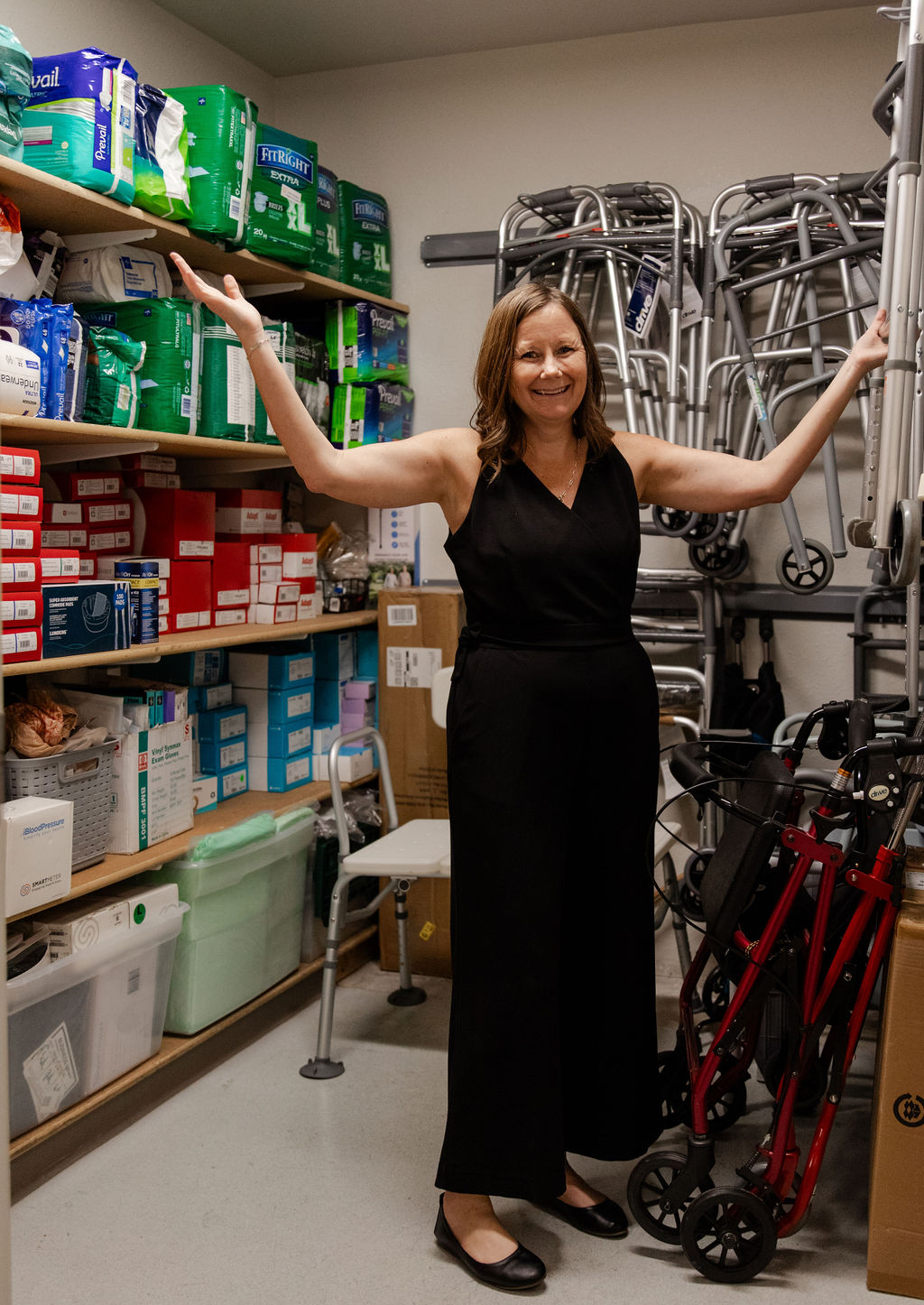 Woman excitedly showing off the many durable medical equipment supplies AllThrive 365 has in our Kindness Closet.