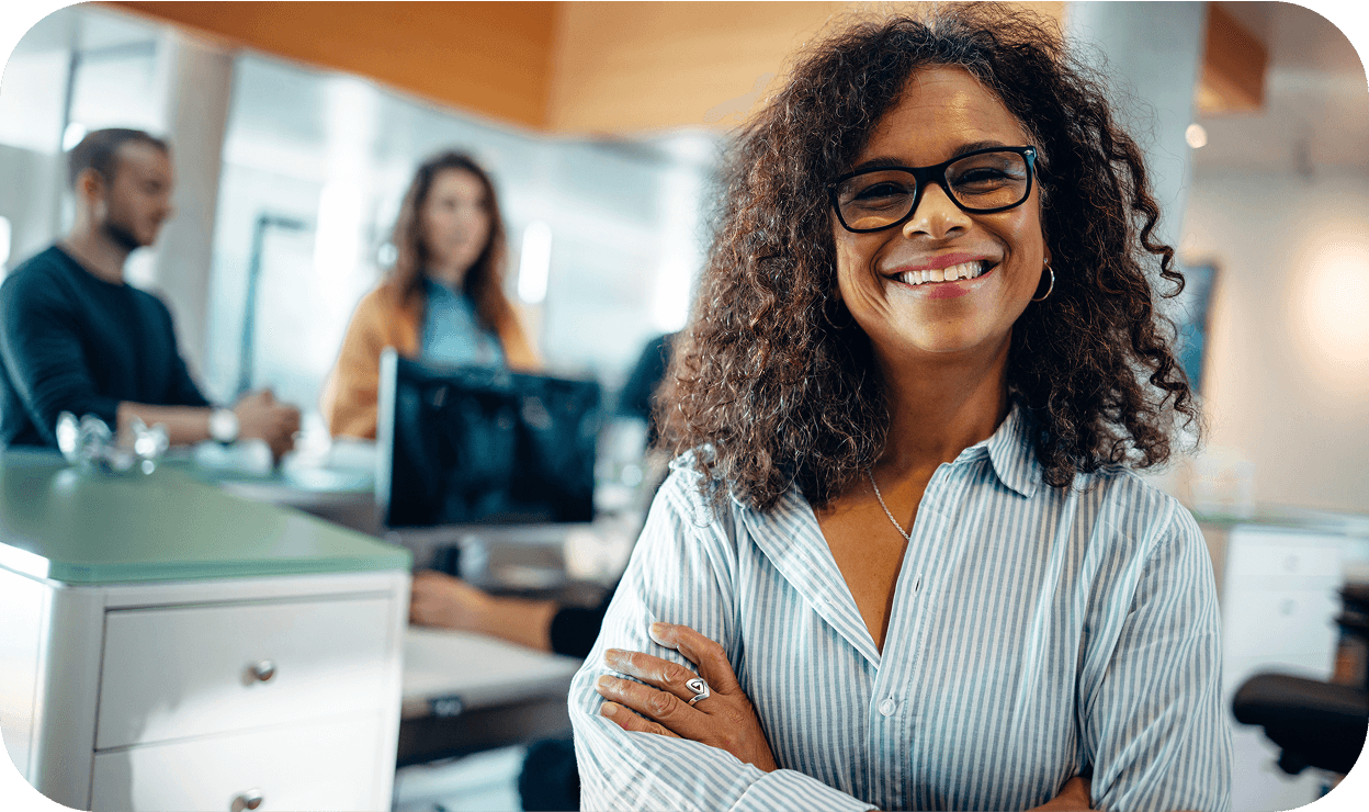 a woman standing proud in front of the rest of the call center in the background