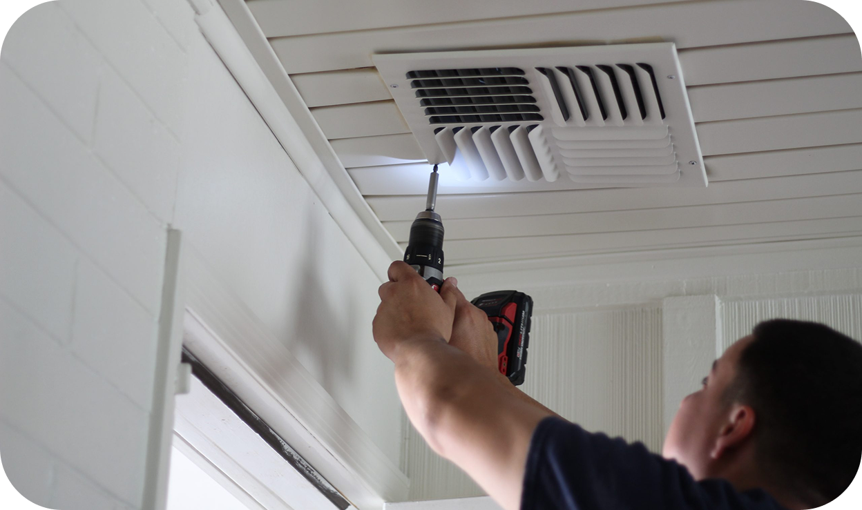 A man repairing an air duct vent