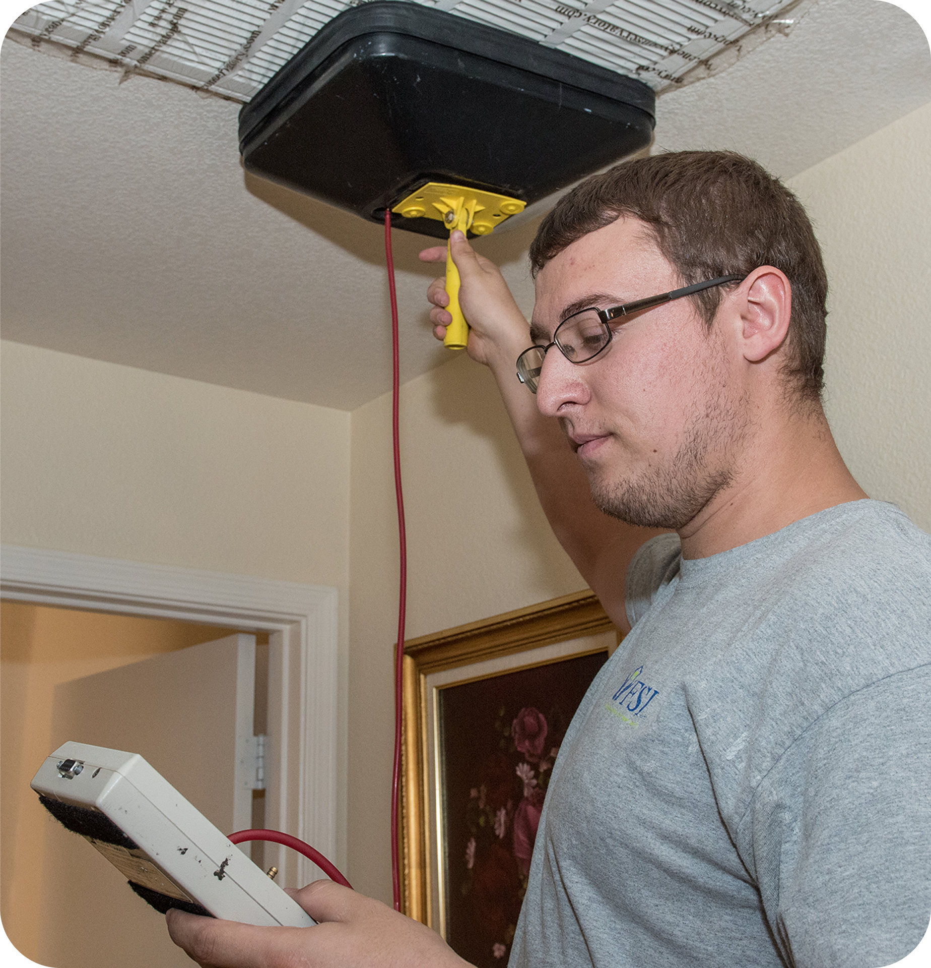 A man performing an air flow test on a vent in a home